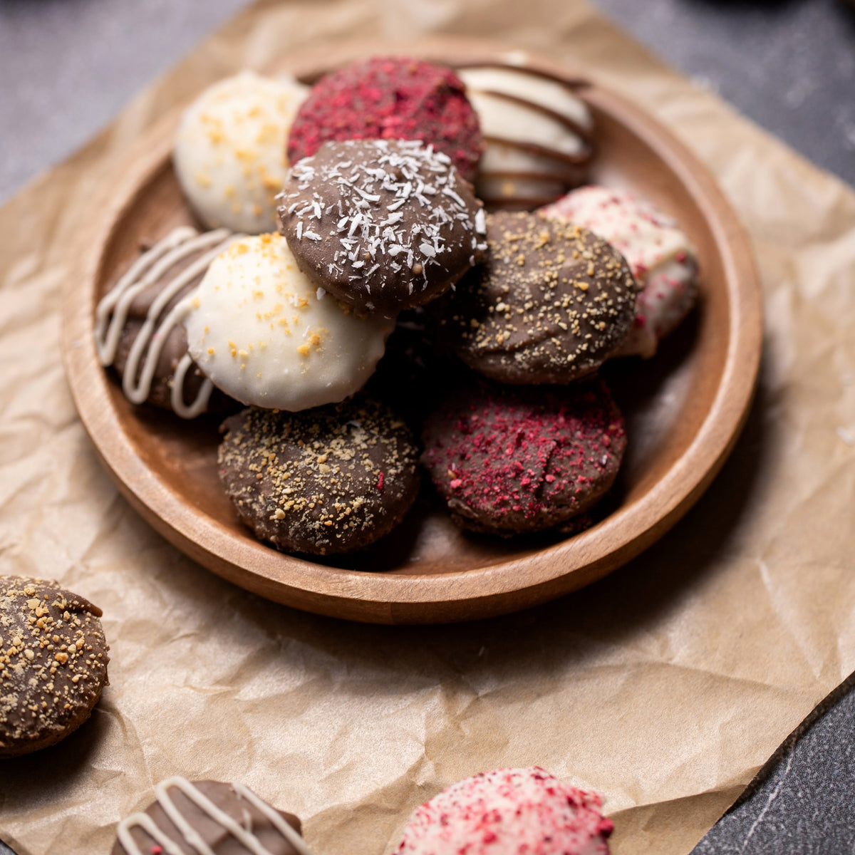 Assorted chocolate truffles on a wooden plate with a rustic background