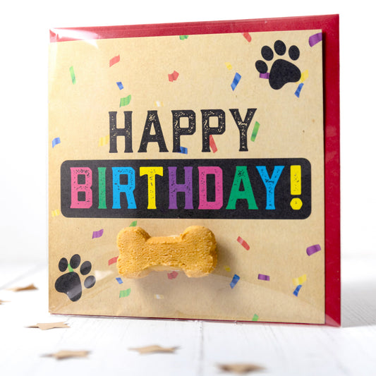 Dog birthday card with colorful text and a bone-shaped treat on a white background