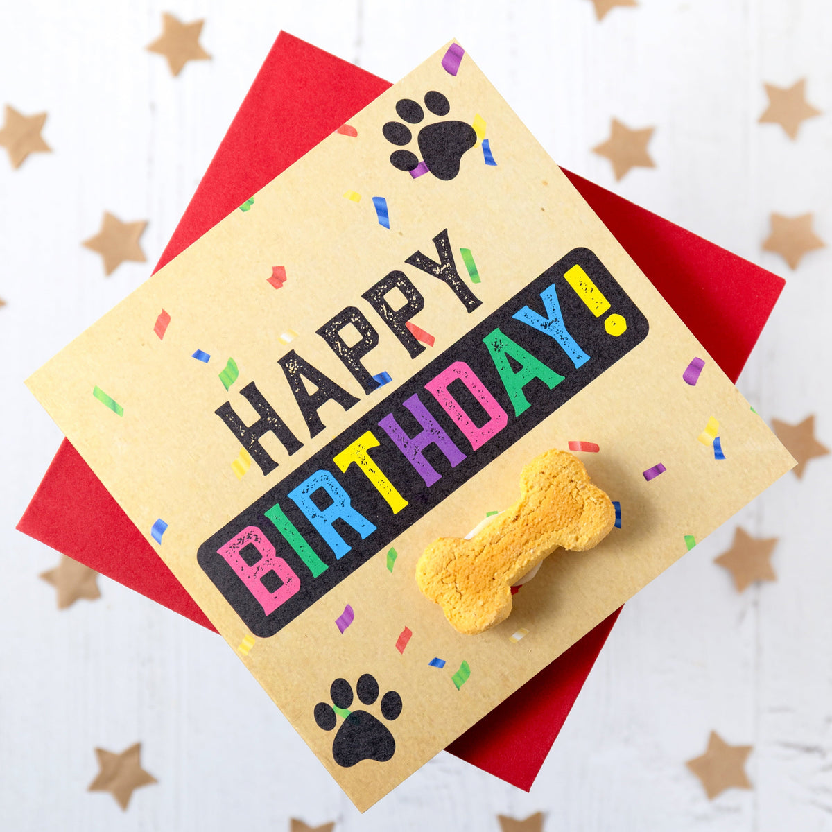 Dog birthday card with colourful text and a bone-shaped treat on a white background with star decorations.
